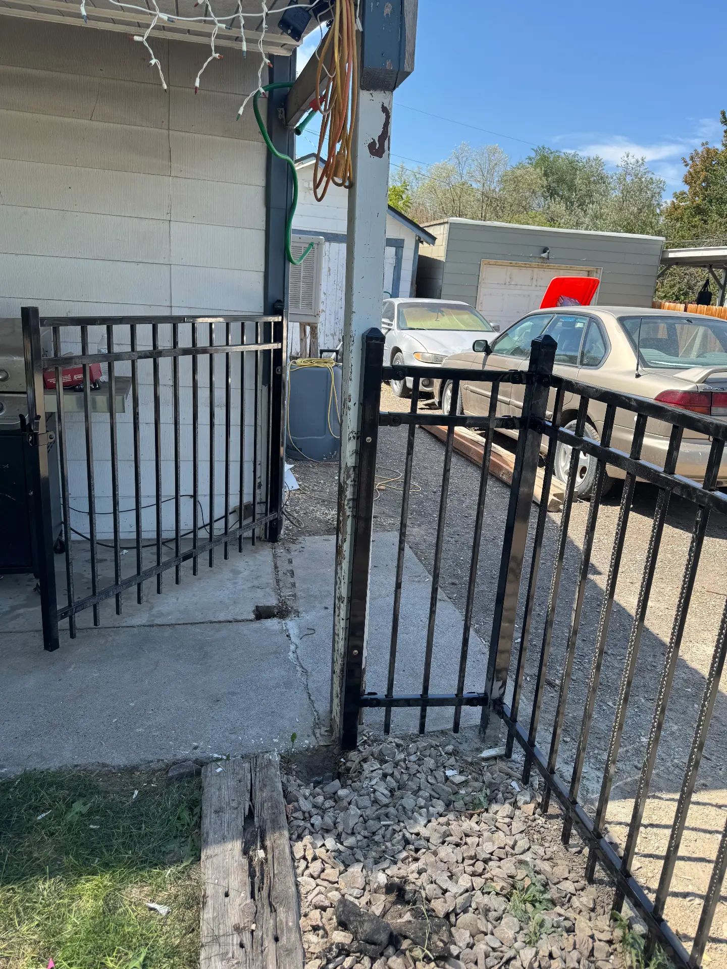 Black ornamental iron fence gate enclosure by a patio — R & R Construction, Burley Idaho