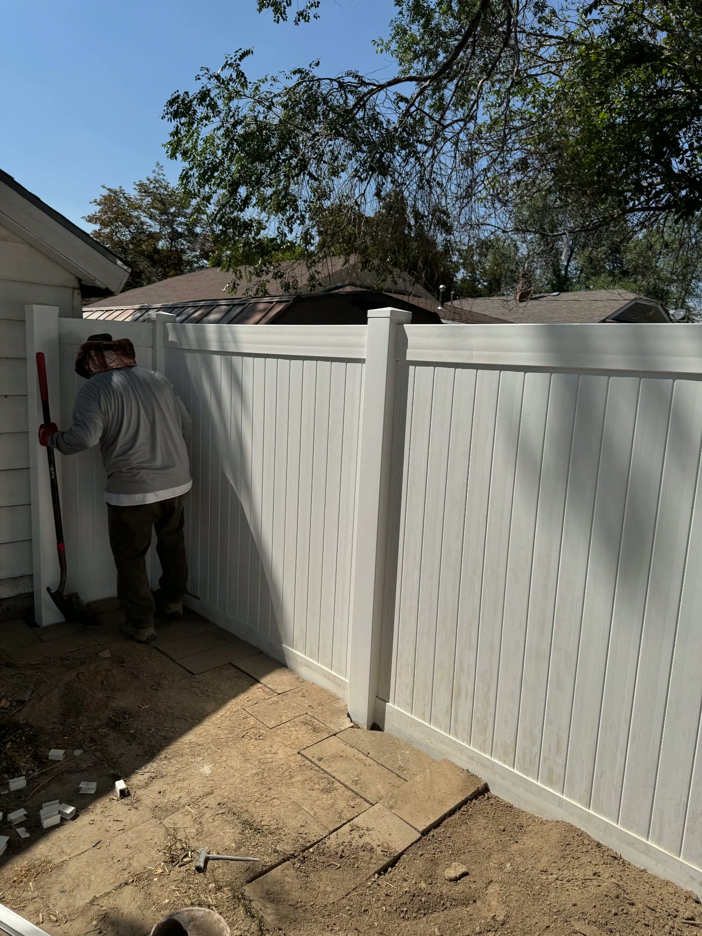 Crew setting the final panels of a white vinyl fence — R & R Construction, Burley Idaho