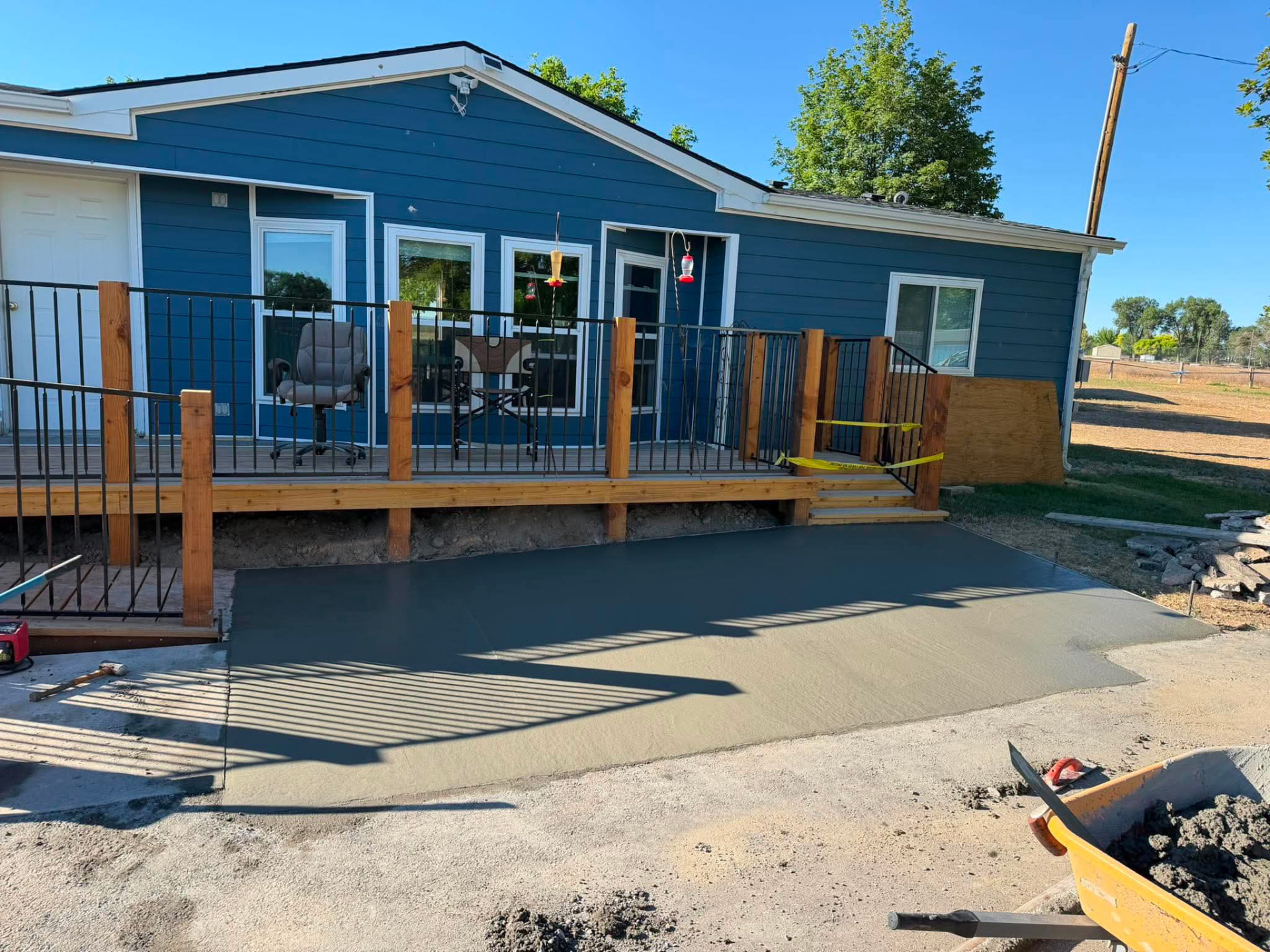 Fresh broom-finished concrete patio slab by a cedar deck — R & R Construction, Burley Idaho